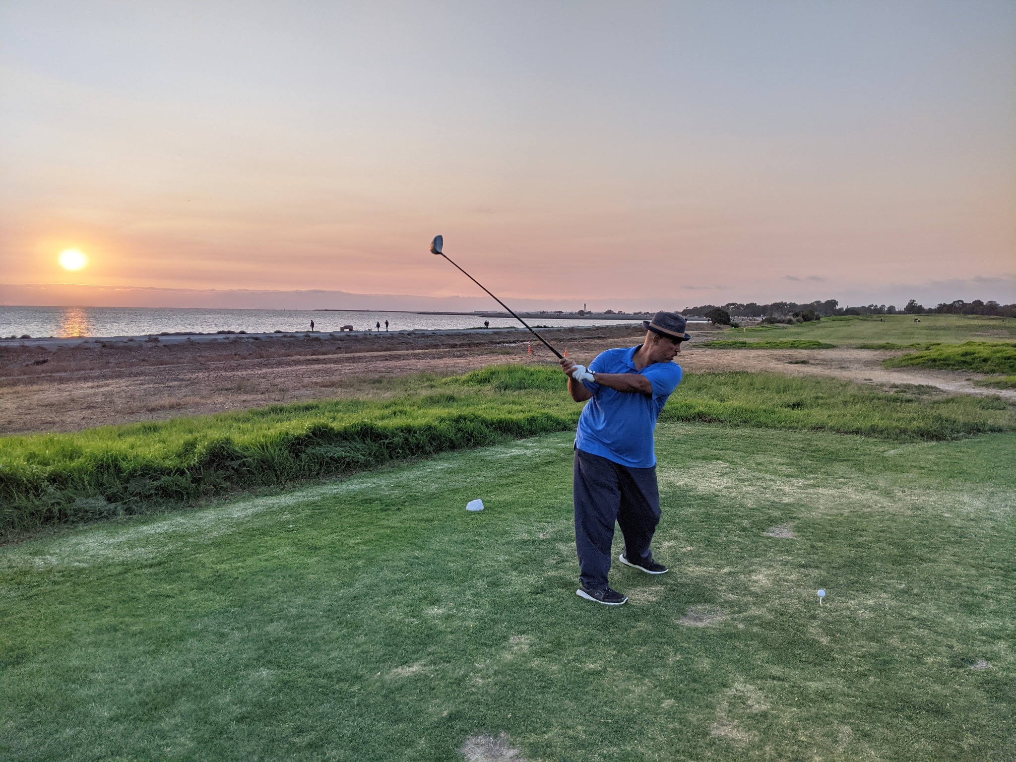 Cordell Davenport golfing beside the water at sunset